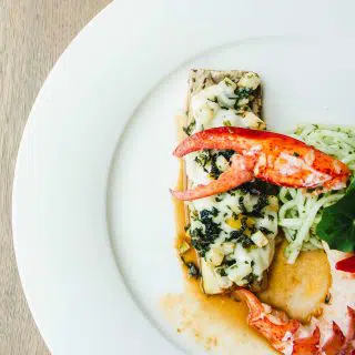 Cooked seafood dish with lobster claw garnished with premium balsamic vinegar