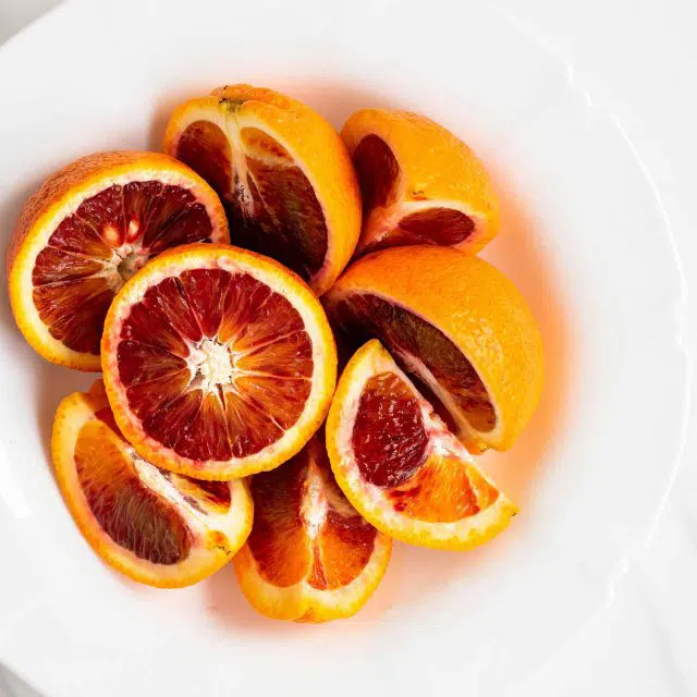 White bowl of sliced blood oranges