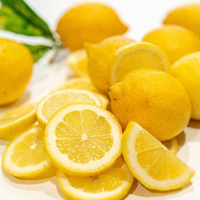 Whole and sliced lemons on a white background