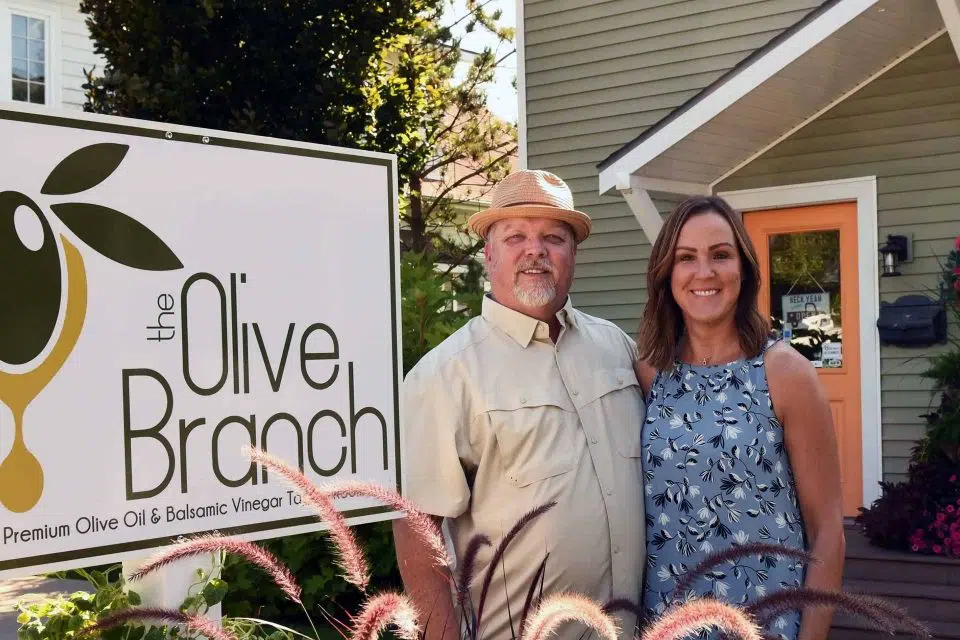 Billy and Maria Hutchison in front of The Olive Branch sign