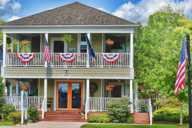 Exterior of The Olive Branch decorated with American Flags for the 4th of July