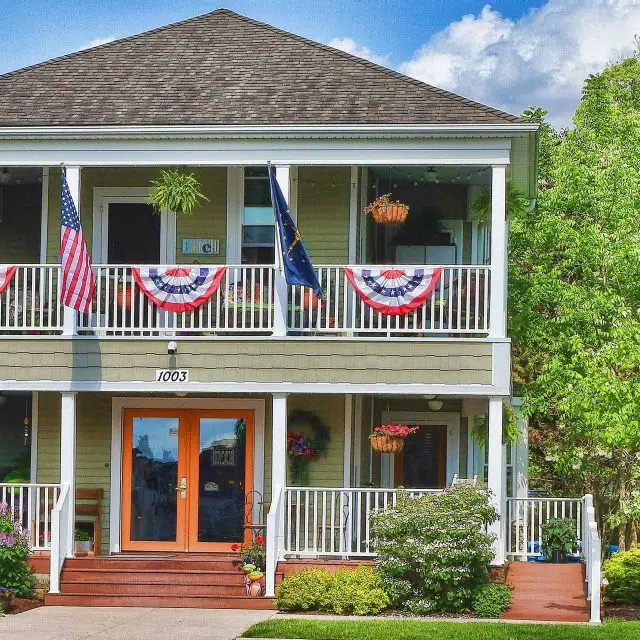 Exterior of The Olive Branch decorated with American Flags for the 4th of July