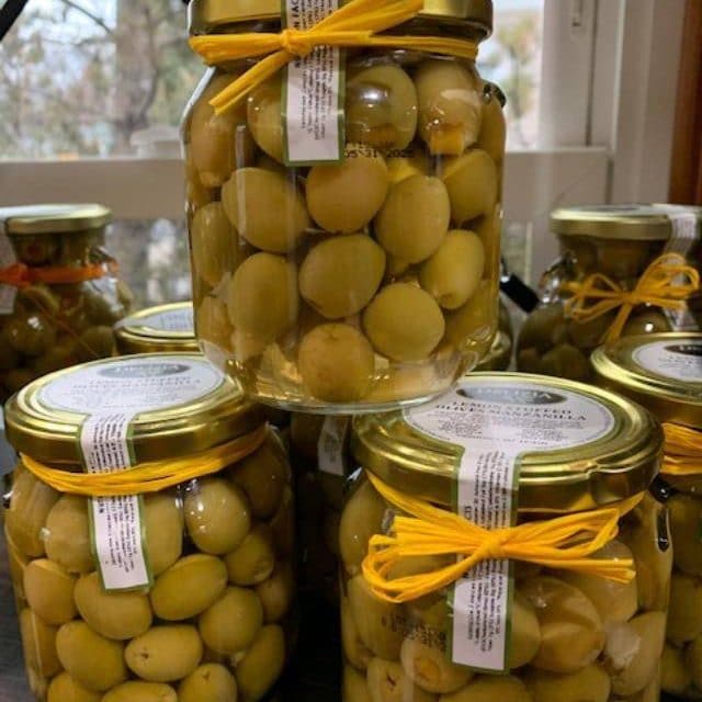 Glass jars of green olives tied with yellow string